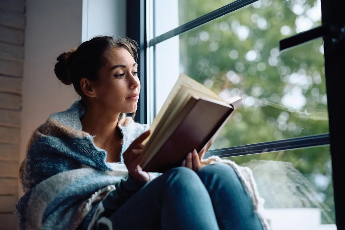 Pencere kenarında kitap okuyan